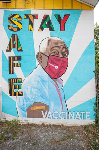 Mural of a man wearing a mask encouraging residents to Stay Safe