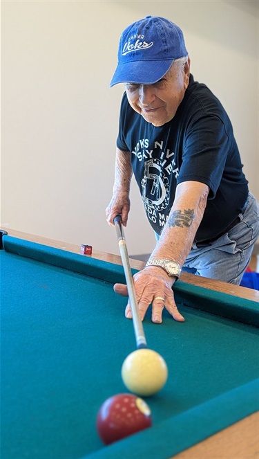 An older man enjoying a game of pool