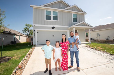 Family standing in front of their home