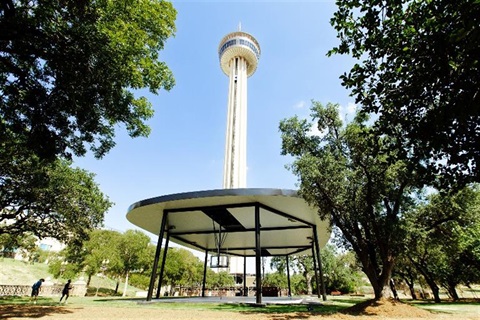 A community basketball court with the Tower of Americas in the background. 