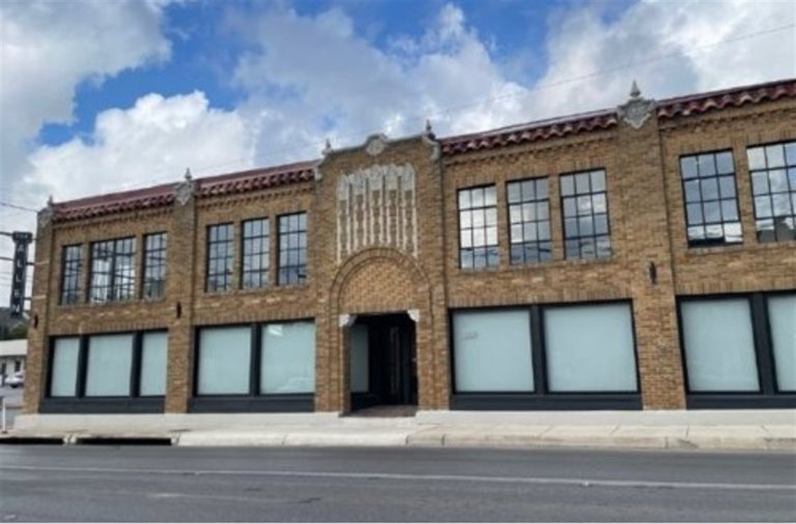 A two-story historic brick building with decorative architecture, including an ornate entrance and rectangular windows.