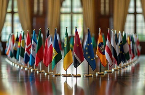 A collection of country flags lined up on a table, showcasing diverse national or organizational identities in a vibrant display.