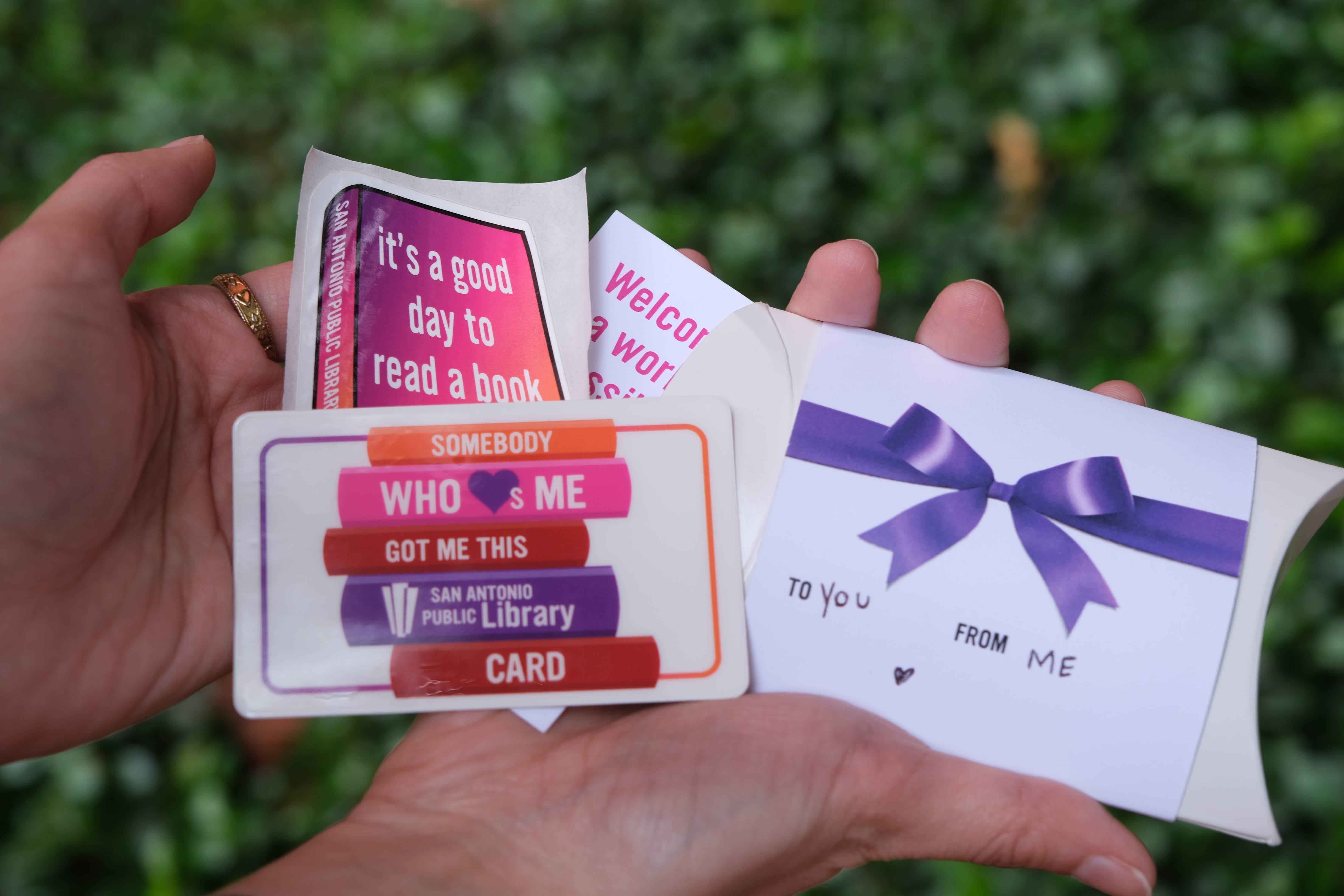 A person holding a library card as a gift