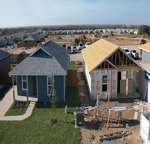 Rancho Carlota photo shows two single family homes - one grey home completed and the other under construction.