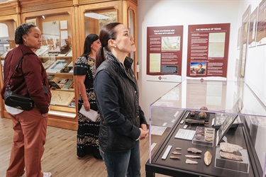 A group of individuals standing in front of a museum exhibit inside the Municipal Archives Museum during the Grand Opening.