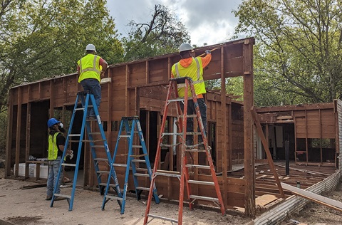 Men working on wooden house frame