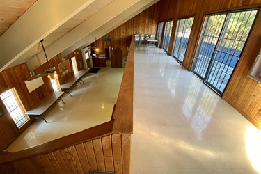 Wooden-walled building with a long staircase leading to the second floor.