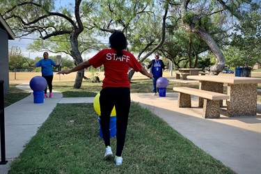 Two people exercising with an instructor outside