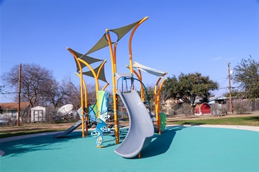 Front view of a playground featuring a canopy and two slides.