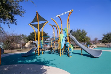 A playground featuring a canopy and two slides.