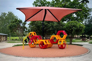 Red and yellow hexagon climbing shapes under a large red shade canopy.
