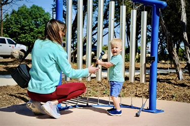 Mother and child playing with oversized xylophone