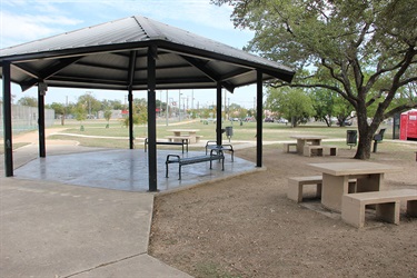 Covered benches next to a couple of picnic tables