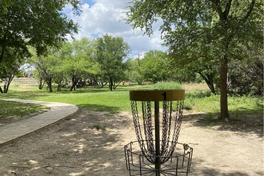 A scenic frisbee golf course in a lush park setting.