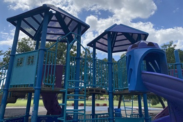 Children's playground with blue equipment and slide.