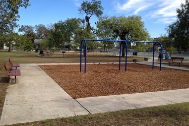 Playground with swings and benches for kids to play and relax.