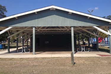 A roofed picnic space with tables and chairs for gatherings.