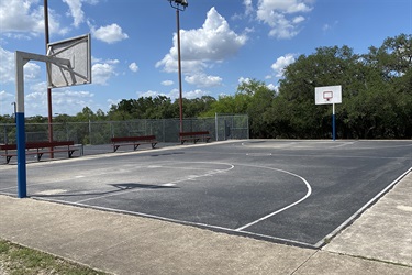A basketball court with a hoops and benches.