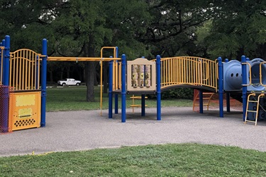 A playground with a slide, slide, and climbing structure.