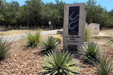 A trail sign with a scenic landscape area.