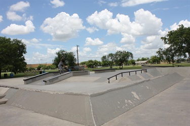 A skate park with two ramps, one for skateboarding and another for BMX biking.