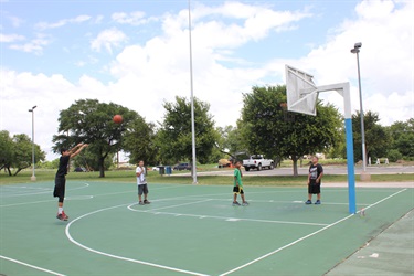 A group of kids playing basketball on a court.