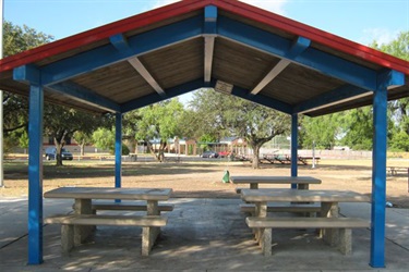 Picnic tables under a blue and red roof.
