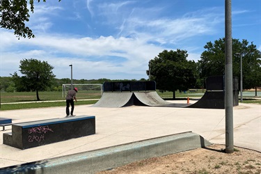 A skateboarder gracefully rides a ramp at a skate park.