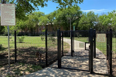 Entrance gate with large dog park sign.