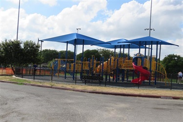 A playground under a clear blue sky with beautiful white clouds.