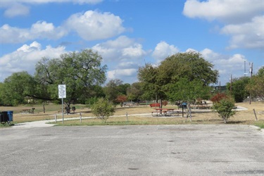 A parking lot with a few trees, providing shade and adding a touch of nature to the surroundings.