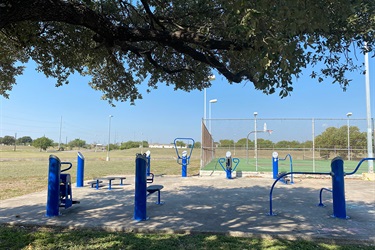A park featuring a basketball court and a blue fitness station.