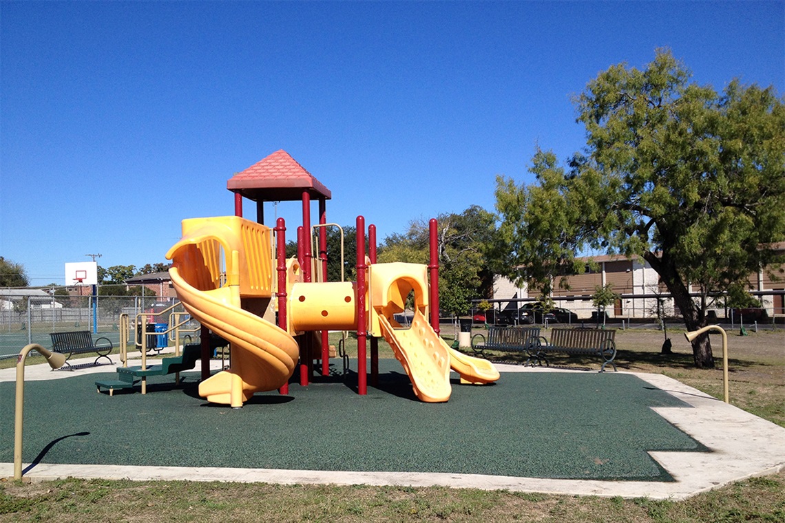 A playground with a slide and a slide cover.
