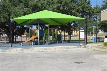 Green canopy shades playground equipment.