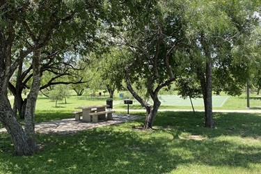 Park bench with basketball court in background