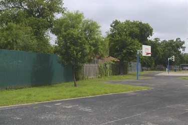 A basketball court with a hoop and fence.