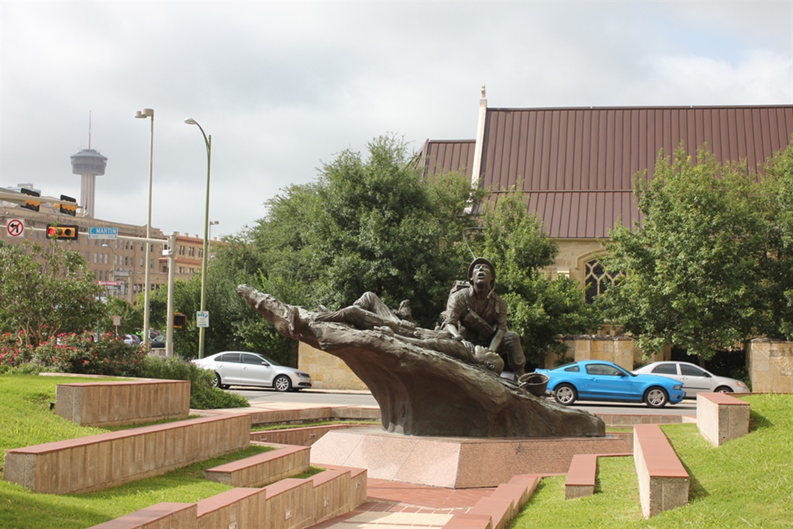 A stone statue of a man perched on a rock