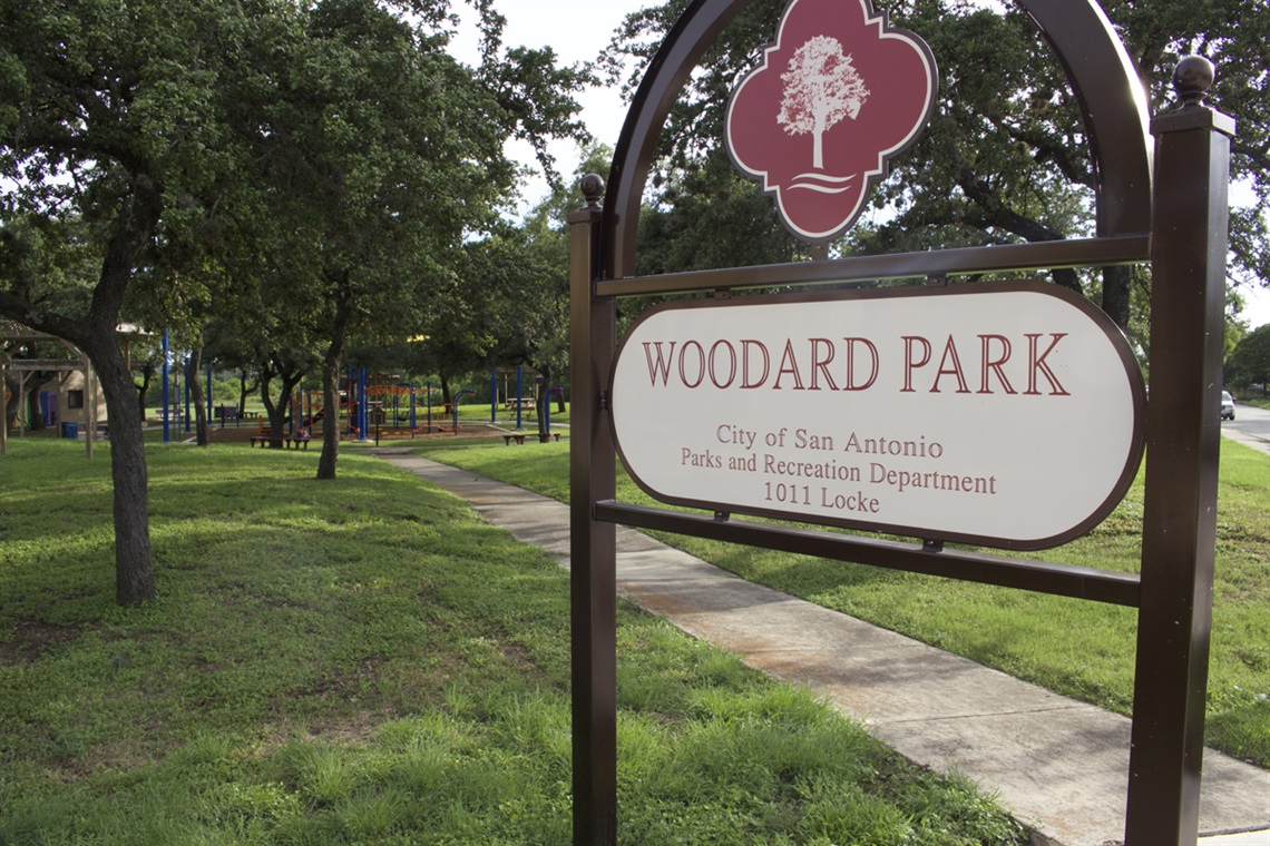 Woodard park sign with walkway in background