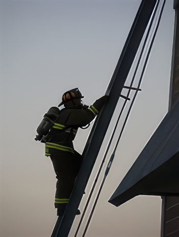 Firefighter candidate climbs a ladder during Ladder Raise and Extension CPAT event.