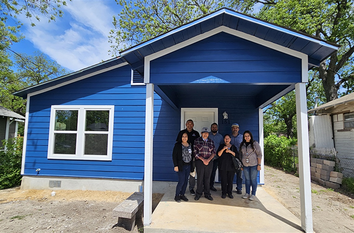 mixed group of people in front of a house