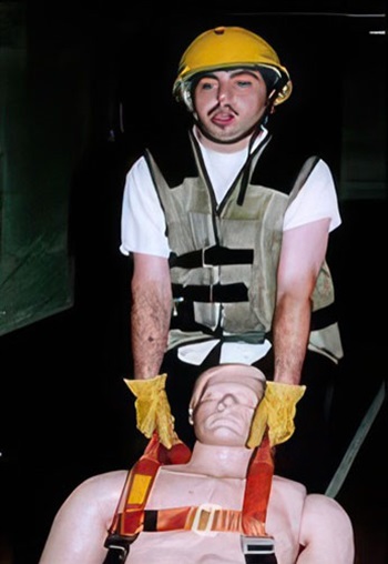 Firefighter candidate pulls mannequin by harness during CPAT Rescue event.