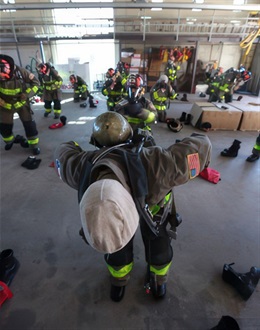 SAFD firefighter candidates practice donning gear.