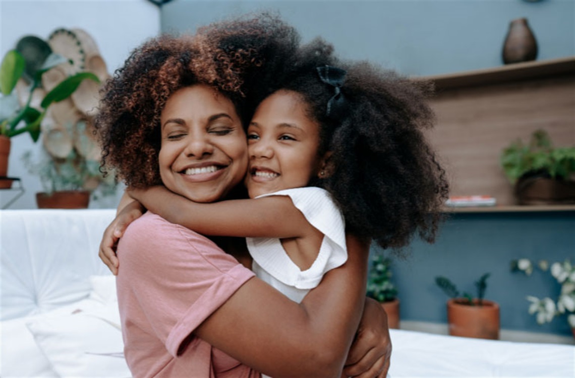 Mother hugging her daughter.