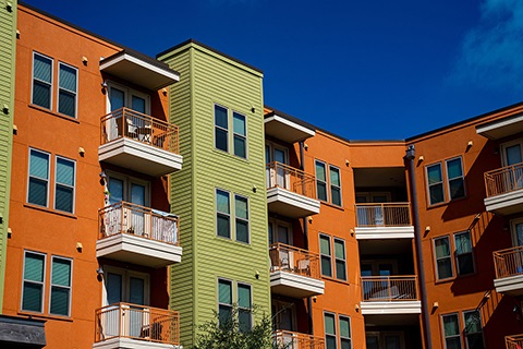 The back side of a multi-family housing unit with over hanging porches.