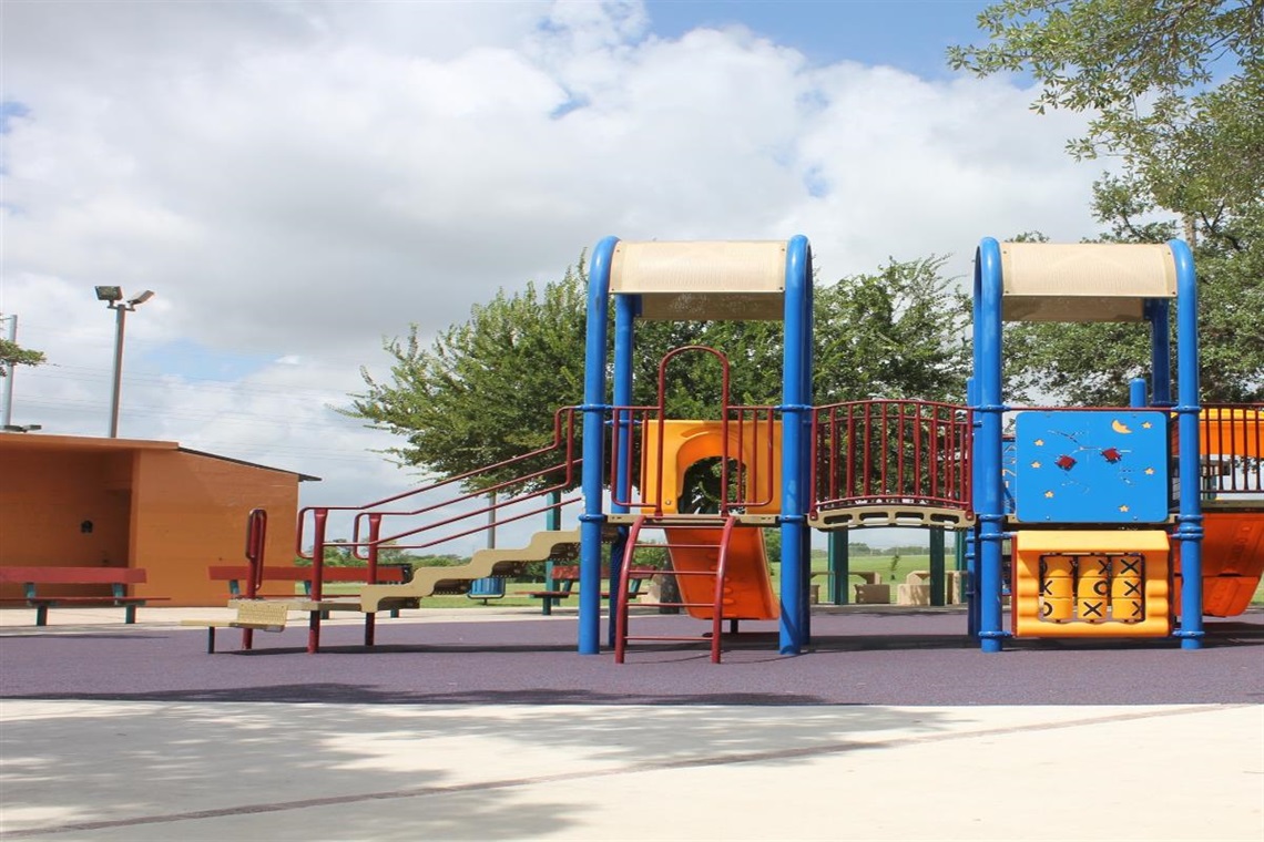 A colorful playground with a slide and climbing wall.