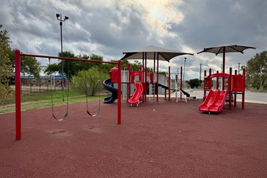 Red playground with slides and swings.
